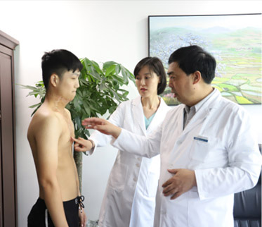 张帆医生与罗蕊主任为公益救助患者小龙检查烧烫伤疤痕部位